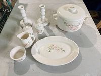 Entire set laid out: casserole, platter, creamer, sugar bowl, shakers, candlesticks