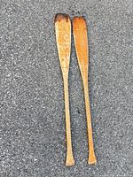 Full view of both wooden oars on ground