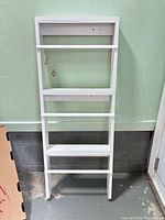 Full view of white 4-tier leaning shelf