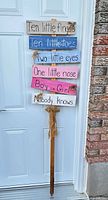 Full view of wooden yard sign leaning against door