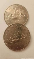 Two coins showing reverse Voyageur canoe design dated 1976