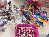 Overview of lot including horses, Strawberry Shortcake dolls in pink bin, Tolo house and figures