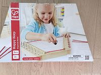 Retail box showing Hape Happy Harp branding and age info