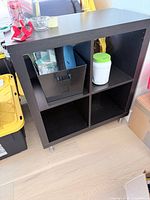 Front view of 2x2 cube shelf showing compartments and items for scale