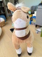 front view showing plush pony, bridle, saddle, handles