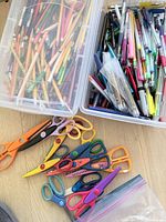 Bin of coloured pencils, pens, markers and craft scissors