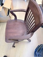 oblique top view showing seat, arm, slatted back, casters