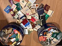 Two tins tipped with large quantity of matchbooks spilling out