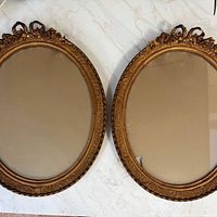 Full view of both oval gold frames showing size and overall design