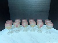 Front view showing all 12 frosted multicolor goblets on marble surface