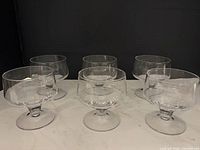 Group shot of six clear coupe dessert glasses
