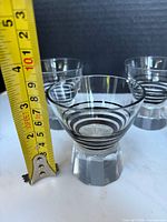 Three dessert cups next to tape measure showing height