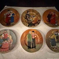 All six decorative plates displayed on flat surface