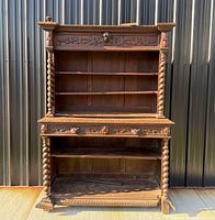Full view showing cabinet with barley twist columns, open shelves and drawer section