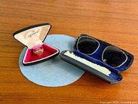 Ring in Marvel case and clip-on sunglasses in case displayed together