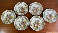 Six of the dinner plates arranged to show front design, colour and gilding