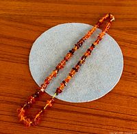 Full view of amber nugget necklace laid straight.