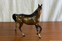 Front three-quarter view of the Beswick bay horse figurine on wood surface