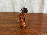 Full view of figurine upright on wooden surface