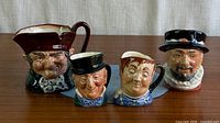 Front view of four Royal Doulton character jugs