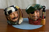 Front view of both jugs showing facial detail and handles