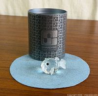Faceted crystal puffer fish figurine beside original Swarovski cylinder box