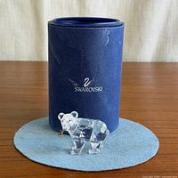 Figurine standing in front of Swarovski box on felt mat