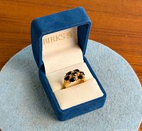 Ring in open blue velvet Birks box showing cluster design