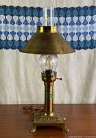 Full view of brass table lamp with chimney and shade