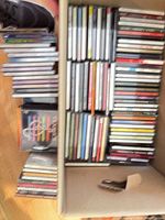 Box divided into two sections filled with rows of CDs plus additional stacks alongside