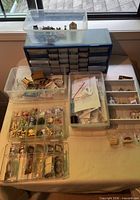 Table with clear compartment boxes, blue drawer cabinet, miniature items visible