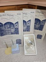 Three sealed Calico Moon PK-503 armoire kits, tray of plastic stands, two metal stands and blue box