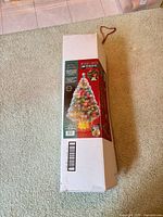 Closed white cardboard box of 48 in fiber-optic Christmas tree