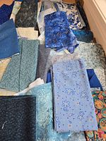 Overview of assorted blue and multicolor fabric remnants spread out