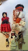 Five assorted dolls including fur-trimmed Inuit doll, flamenco doll, two Native dolls, small baby doll and toy guitar