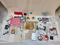 Overall lot view showing kits, canvases, stitched samples and fabric