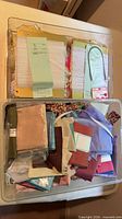 Clear bin containing assorted fabric scraps and carded trims