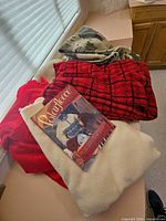 Pile of four blankets and Polarfleece book