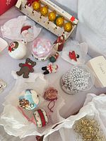 Grouped view of assorted ornaments, garlands, hooks and boxed glass balls