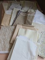 Group view of stacked cream, beige, patterned fabric pieces