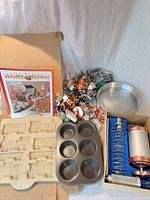 Group shot of all baking items including cookie cutters, stoneware mold, muffin pan, cake pans, and boxed cookie press