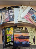Stack of paperback and spiral books spread on table