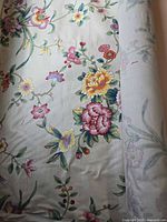 Roll of cream floral upholstery fabric unrolled to show pattern detail