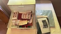 Open drawer showing assorted miniature furniture parts, fabric and instructions