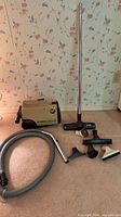 Vacuum body, hose, wand, floor head and accessories laid out