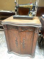 Franklin treadle sewing machine on carved oak cabinet