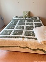 Full bed with quilt, pillow and folded blanket displayed