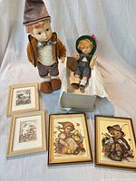 Overall view of both dolls, stand, and four framed prints