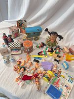 Entire lot laid out showing dolls, tins, figurines, clogs, spiders
