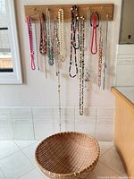 Necklaces hanging on wood board showing variety